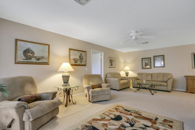 carpeted living room featuring ceiling fan and a textured ceiling