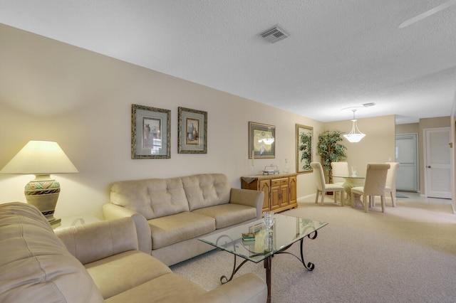 living room featuring light carpet and a textured ceiling