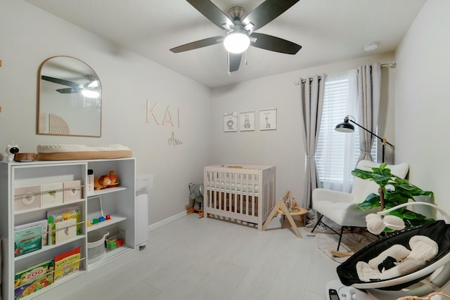 bedroom with ceiling fan and a crib