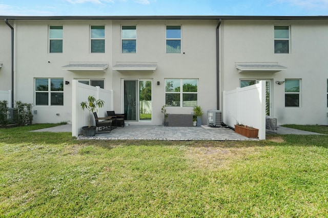 rear view of property with a patio, a lawn, and central air condition unit