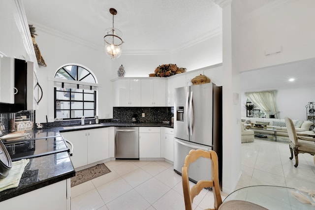 kitchen featuring appliances with stainless steel finishes, crown molding, light tile patterned floors, white cabinetry, and hanging light fixtures