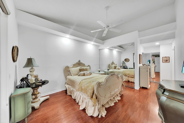 bedroom featuring ceiling fan, a closet, and hardwood / wood-style flooring