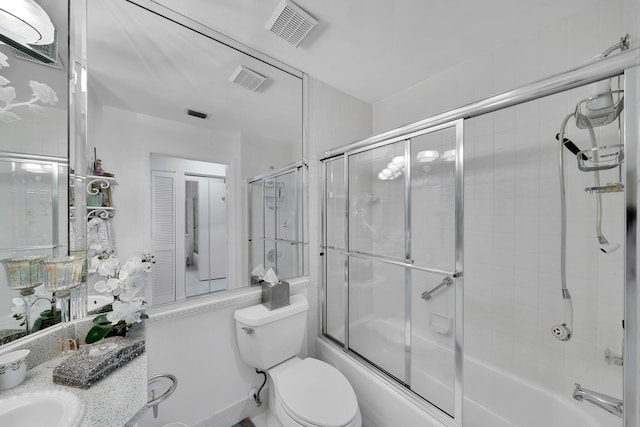 full bathroom with vanity, toilet, and bath / shower combo with glass door