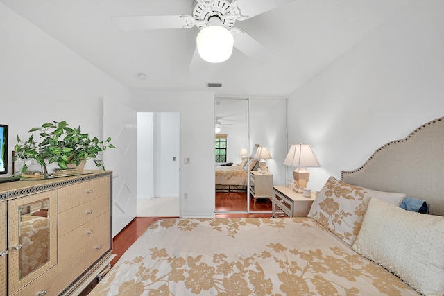 bedroom with a closet, ceiling fan, and dark wood-type flooring