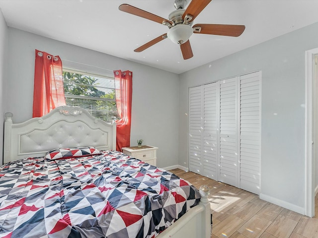 bedroom with ceiling fan, light wood-type flooring, and a closet