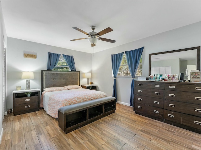 bedroom featuring ceiling fan, light wood-type flooring, and multiple windows