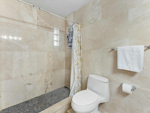 bathroom featuring toilet, tile walls, and curtained shower