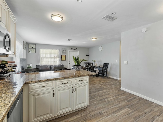 3561 Oberon Ave, Boynton Beach, FL 33436 - kitchen with stainless steel appliances, a peninsula, baseboards, light wood finished floors, and stone counters