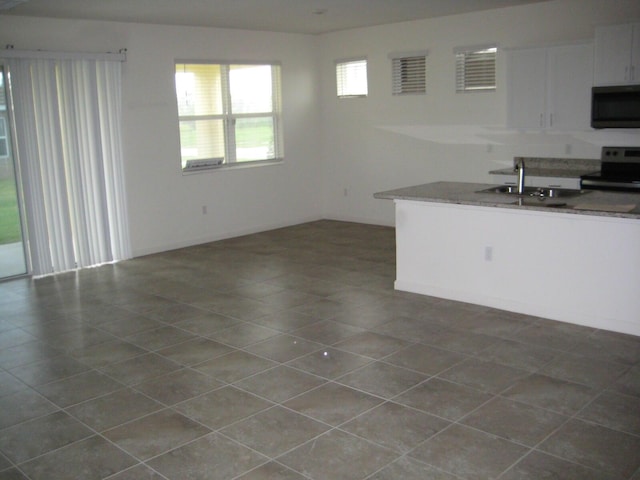 kitchen featuring white cabinets, sink, stainless steel appliances, and dark tile patterned flooring