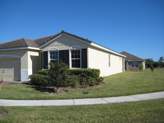 view of side of home with a lawn and a garage