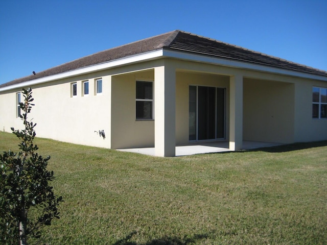 back of house with a lawn and a patio area