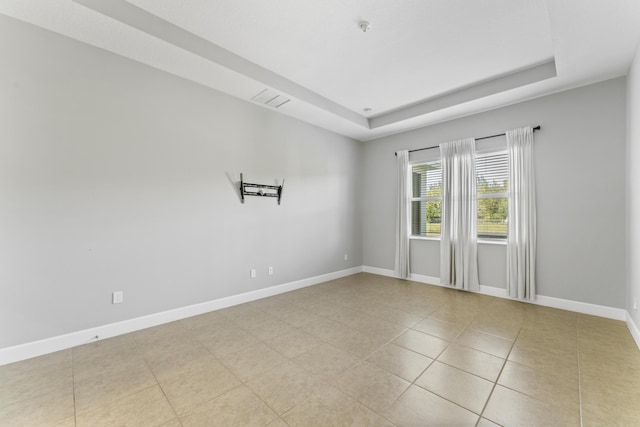 unfurnished room with a tray ceiling