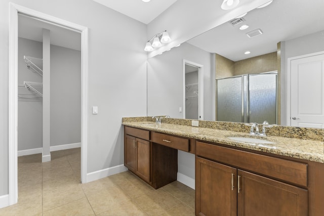 bathroom featuring tile patterned flooring, vanity, and a shower with door