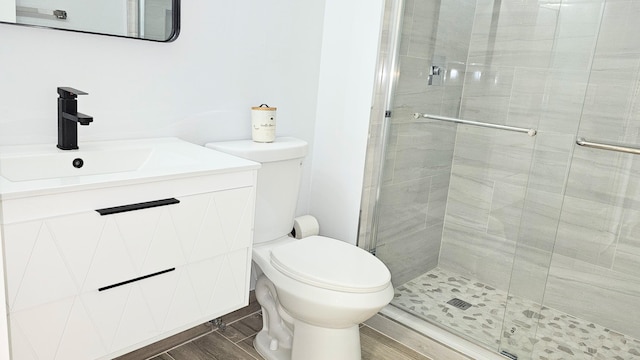 bathroom with vanity, a shower with shower door, and toilet