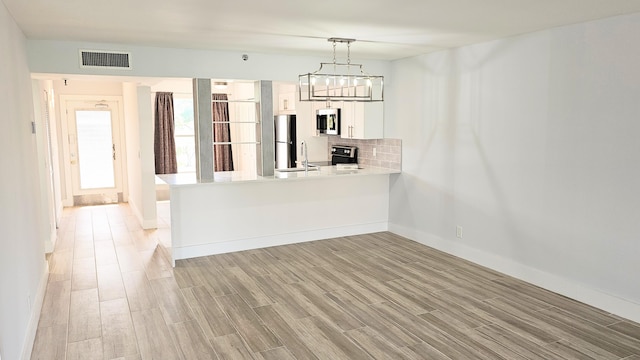 interior space with a notable chandelier, light wood-type flooring, and sink