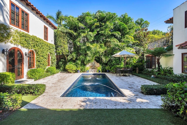 view of swimming pool with pool water feature and a patio