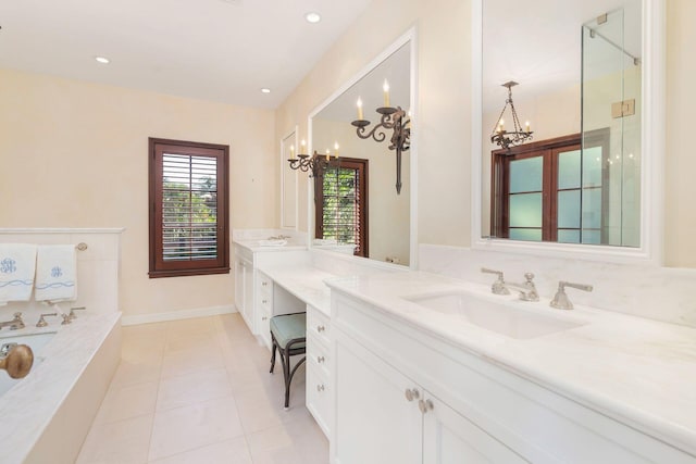 bathroom with tile patterned flooring, vanity, an inviting chandelier, and a tub