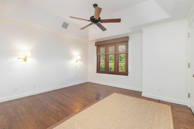 spare room with a raised ceiling, ceiling fan, dark hardwood / wood-style floors, and ornamental molding