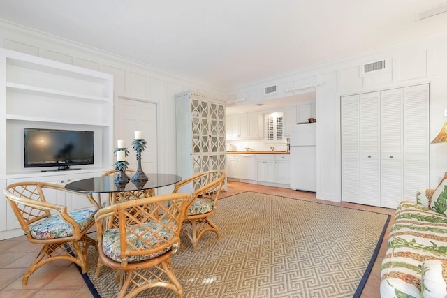 tiled dining room with built in features and ornamental molding