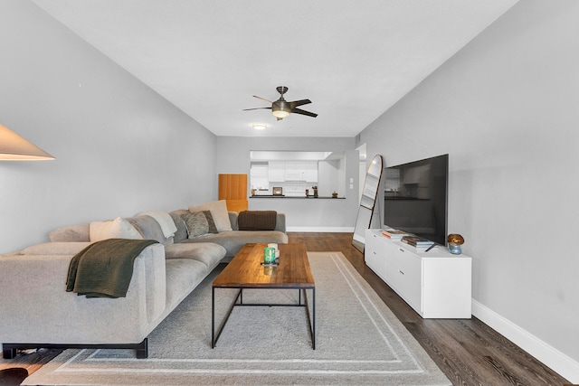 living room featuring ceiling fan and dark hardwood / wood-style flooring