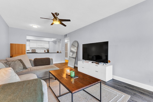 living room featuring ceiling fan and hardwood / wood-style flooring