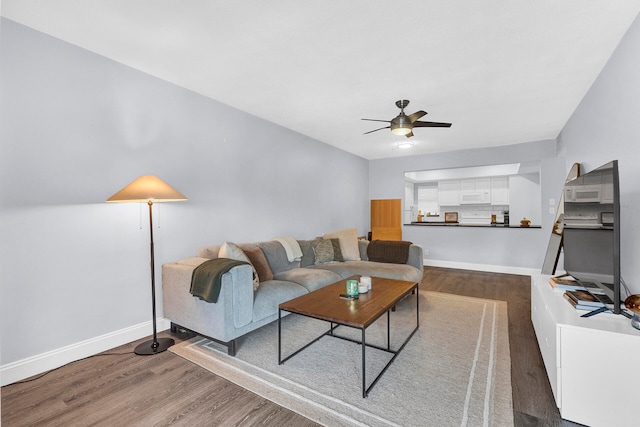 living room featuring ceiling fan and dark hardwood / wood-style flooring