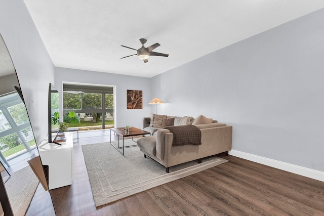 living room with ceiling fan and dark hardwood / wood-style flooring