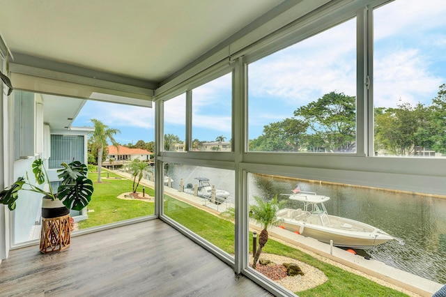 sunroom featuring a water view