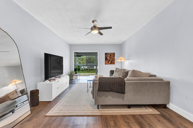 living room featuring dark hardwood / wood-style floors, ceiling fan, and a textured ceiling