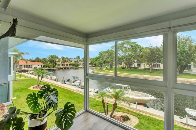 sunroom featuring a water view