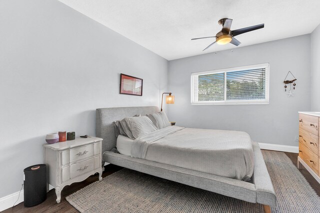 bedroom with dark hardwood / wood-style floors and ceiling fan