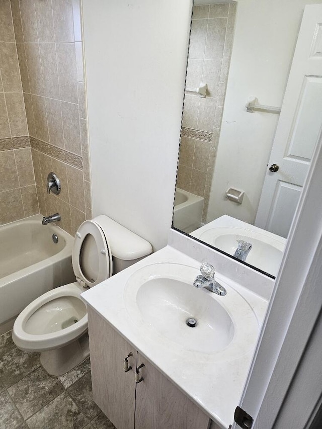 full bathroom with toilet, vanity, and tiled shower / bath