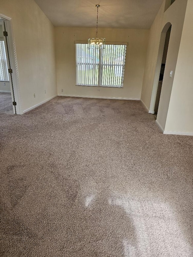 spare room with a notable chandelier