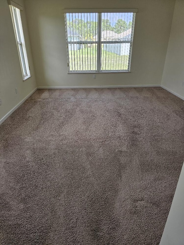 empty room featuring carpet, a water view, and a wealth of natural light