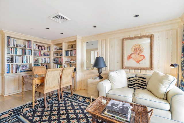 office with hardwood / wood-style flooring, ornamental molding, and built in shelves