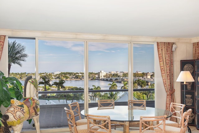 sunroom featuring a water view