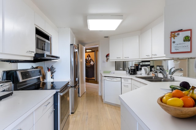 kitchen with white cabinetry, sink, light hardwood / wood-style floors, and appliances with stainless steel finishes