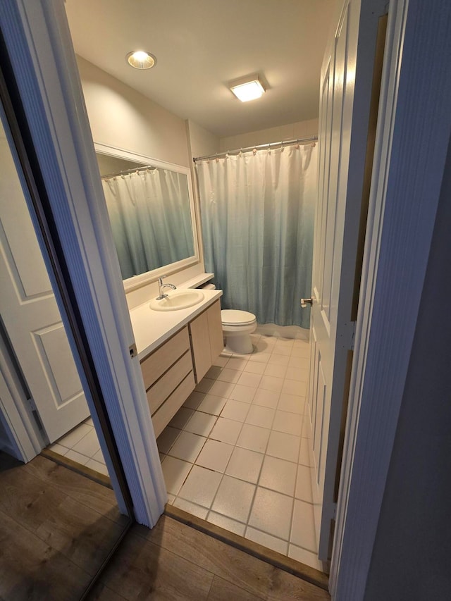 bathroom with wood-type flooring, vanity, and toilet