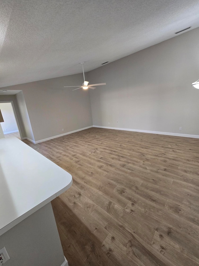 unfurnished living room with wood-type flooring and a textured ceiling