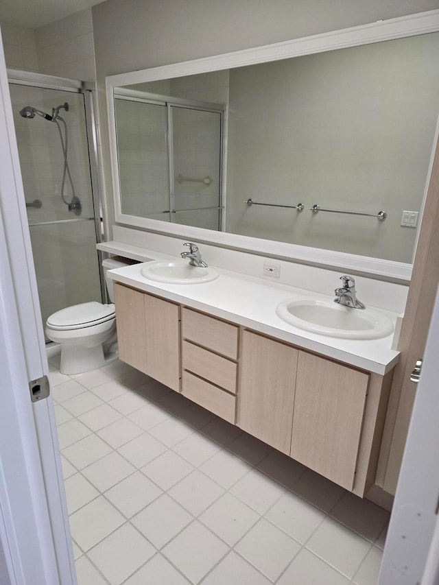 bathroom featuring tile patterned flooring, vanity, toilet, and a shower with shower door