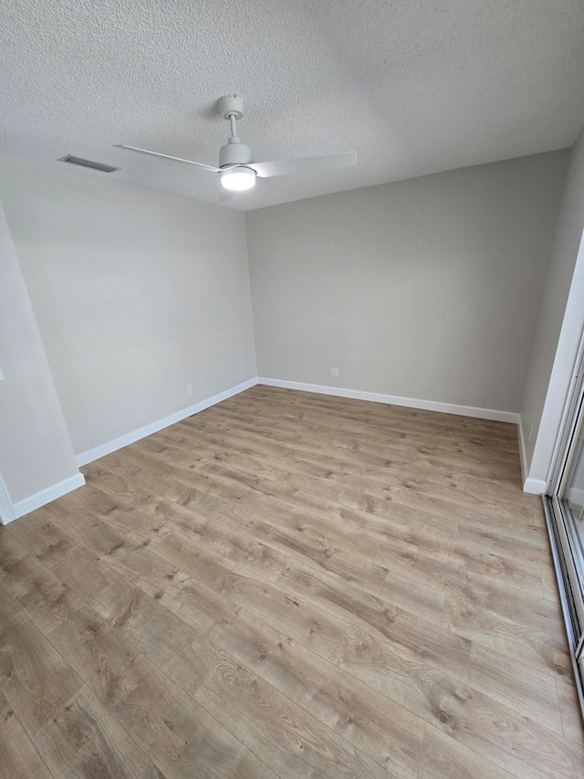 unfurnished room with ceiling fan, light hardwood / wood-style floors, and a textured ceiling