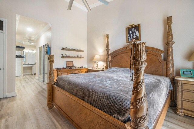 bedroom featuring crown molding, ensuite bath, and light wood-type flooring