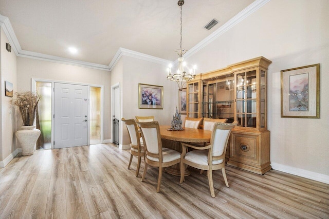 dining room with ornamental molding, a chandelier, and light hardwood / wood-style floors