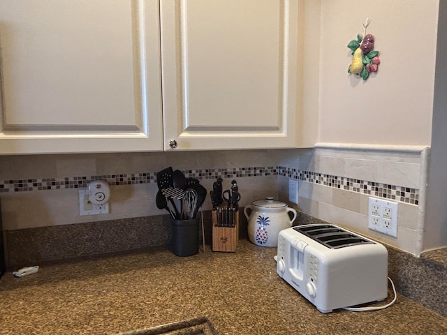 room details featuring white cabinetry and backsplash