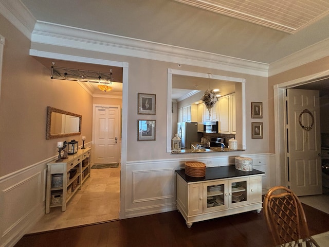 bar with white cabinets, hardwood / wood-style floors, appliances with stainless steel finishes, and crown molding