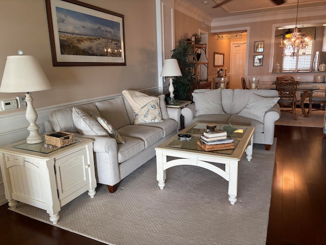 living room with crown molding, dark wood-type flooring, and a notable chandelier