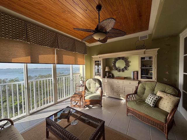 sunroom featuring a wealth of natural light, ceiling fan, and a water view