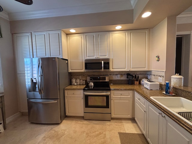 kitchen with white cabinets, decorative backsplash, stainless steel appliances, and crown molding