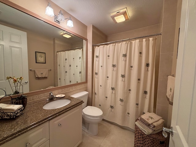 bathroom featuring vanity, tile patterned floors, a shower with curtain, toilet, and a textured ceiling