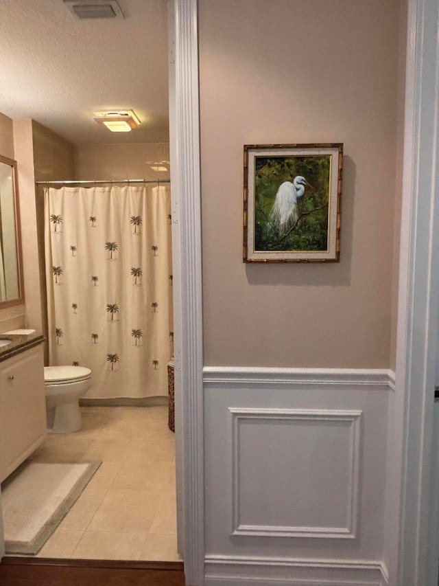 bathroom featuring curtained shower, vanity, a textured ceiling, and toilet